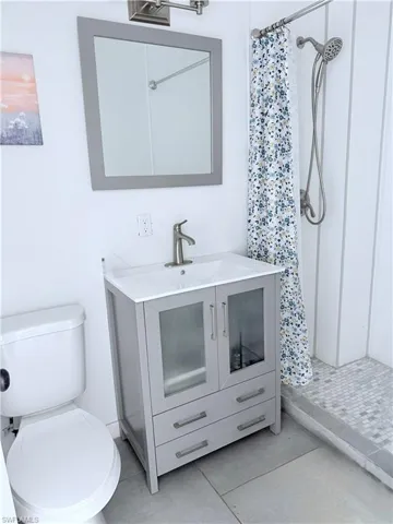 Bathroom with a shower stall, vanity, and tile patterned floors