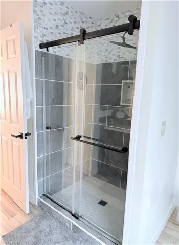 Bathroom with light wood-type flooring and a shower stall