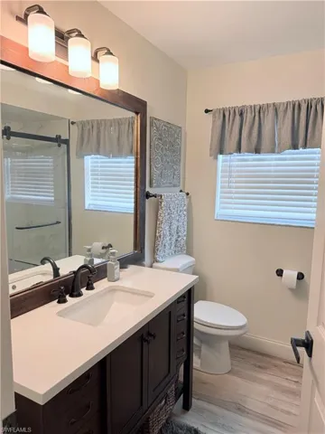 Bathroom featuring vanity, light wood finished floors, and a stall shower