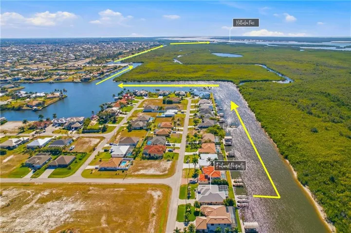 Aerial view of residential area featuring a large body of water and property parcel outlined