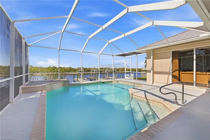 Outdoor pool featuring a lanai, a patio, a sunroom, a water view, and a dock