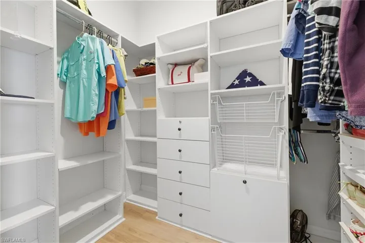 Walk in closet with light wood-type flooring