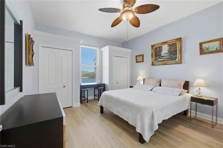 Bedroom featuring multiple closets, light wood-type flooring, and a ceiling fan