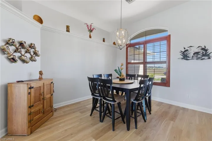Dining area featuring light luxury vinyl flooring and a chandelier
