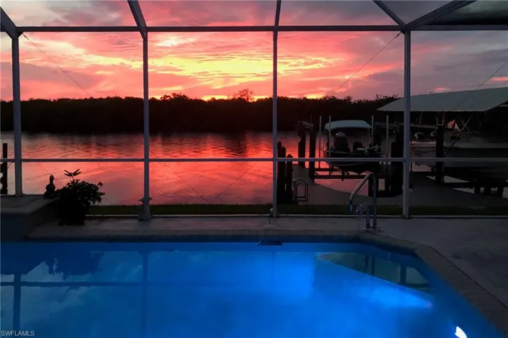 Swimming pool featuring glass enclosure, a boat dock, and boat lift