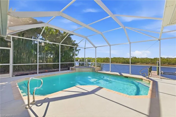 Swimming pool featuring a hot tub, a lanai, a sunroom, and a patio area