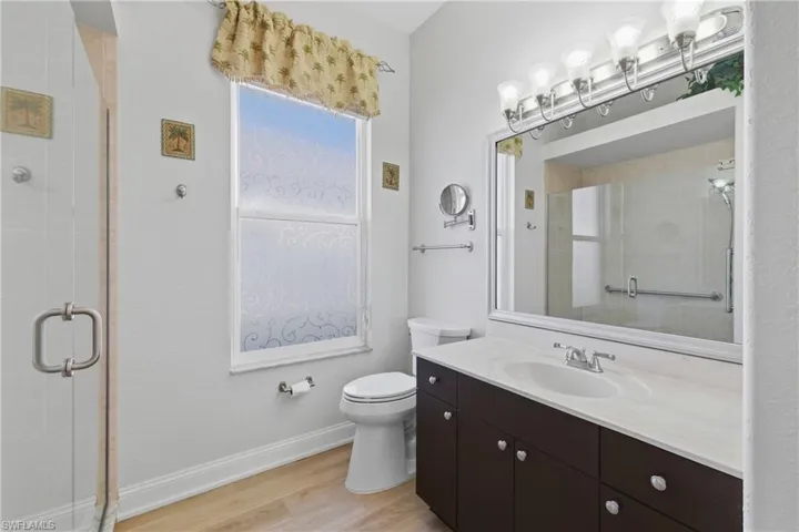Bathroom with a stall shower, vanity, and light wood-style flooring