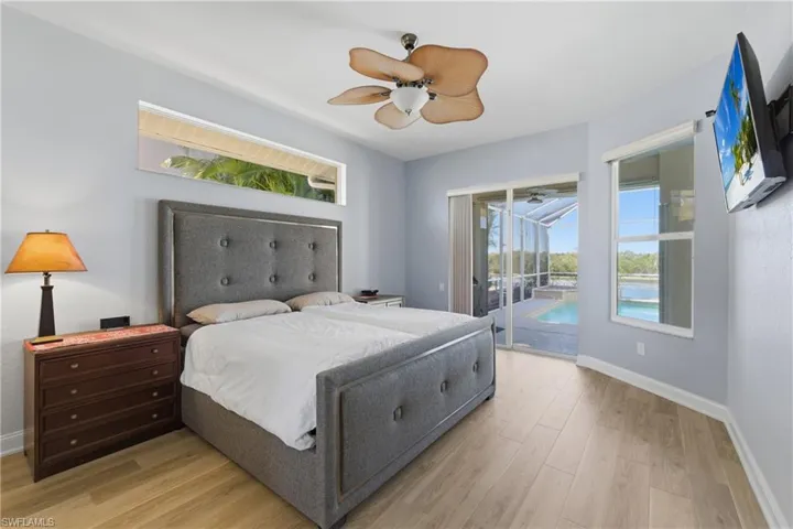 Bedroom with access to exterior, light wood-style flooring, and ceiling fan