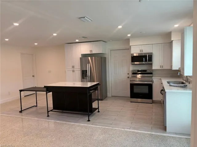 The multi-purpose center island is perfect for this open Kitchen. Good additional counter space and storage (opposite side), counter bar on Living room side and the expandable side table for extra seating (side table slides in to make just the counter island)