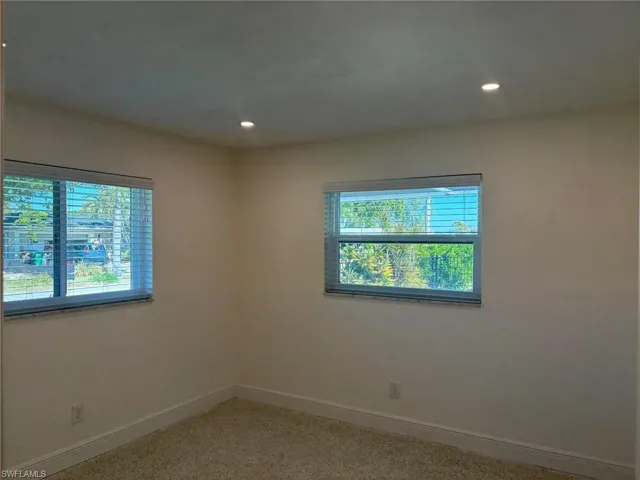 The rear Guest Bedroom overlooks the pool area, features a large closet, terrazzo flooring and recessed lighting.