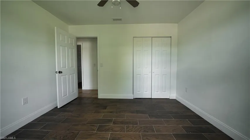 Unfurnished bedroom featuring baseboards, a closet, and ceiling fan