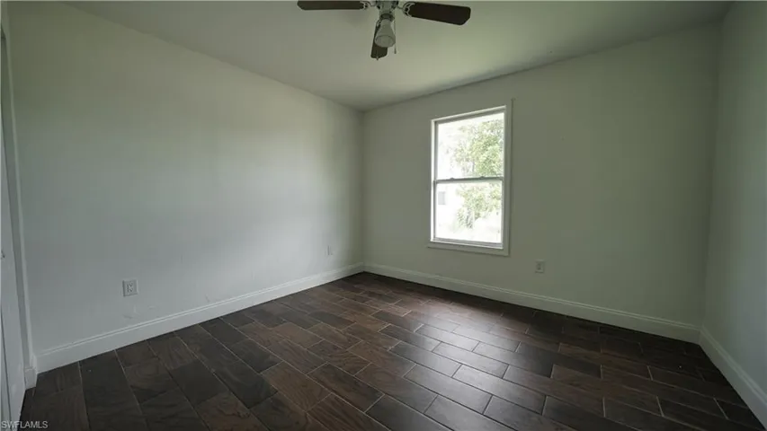 Unfurnished room with baseboards and ceiling fan