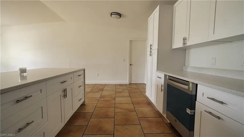 Kitchen featuring dishwasher, white cabinets, and tile patterned floors