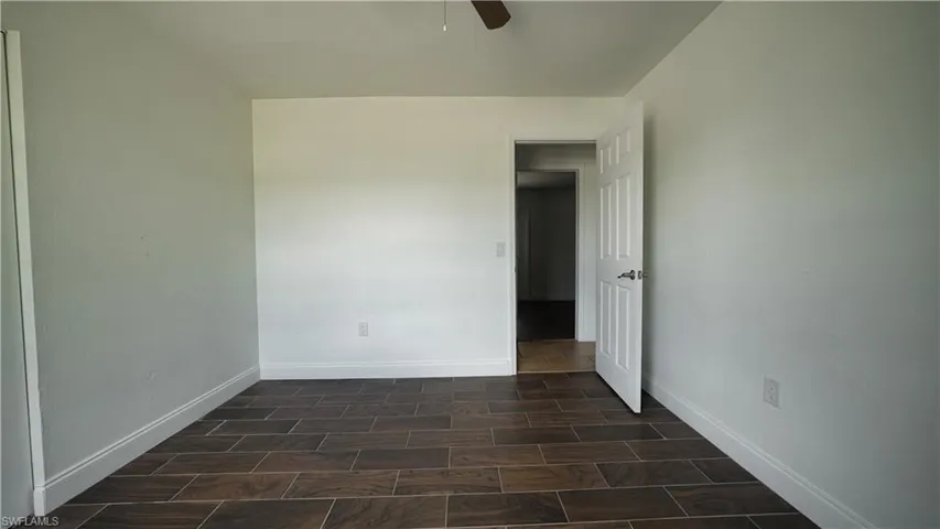 Empty room with a ceiling fan and baseboards