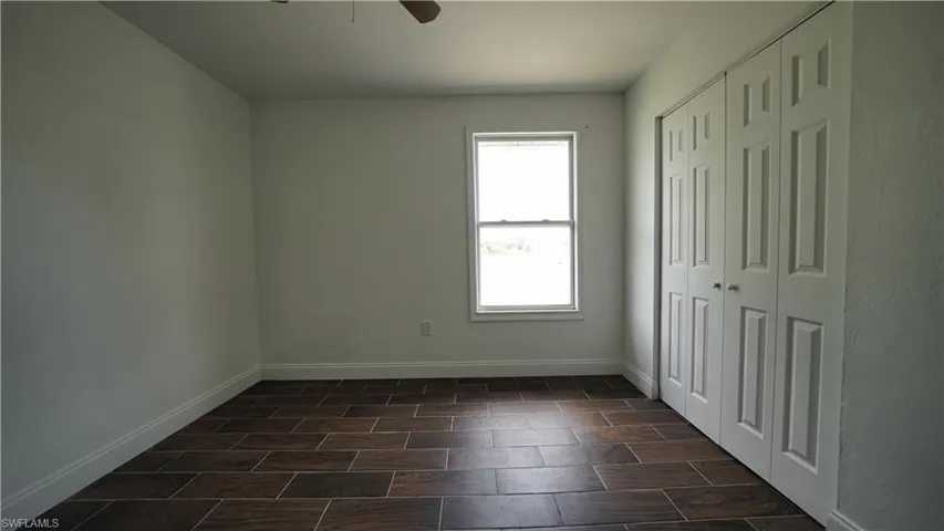 Unfurnished bedroom featuring baseboards, a closet, and a ceiling fan
