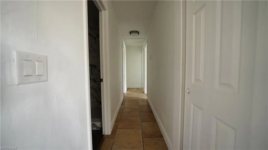 Corridor with tile patterned floors and baseboards