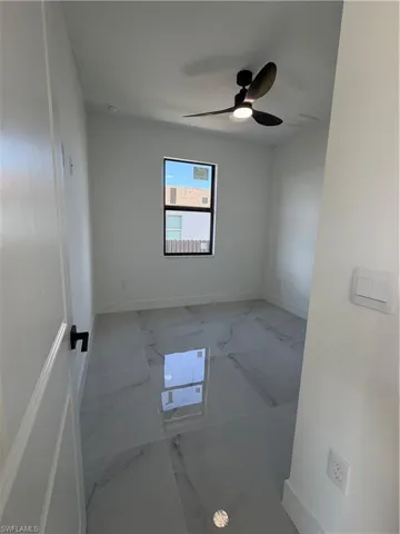 Unfurnished room featuring marble finish flooring and a ceiling fan