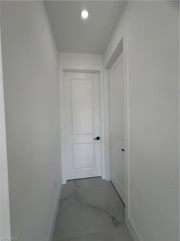 Hall featuring marble finish floors and recessed lighting