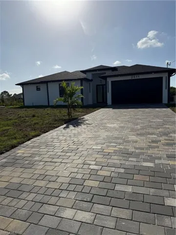 Prairie-style home with decorative driveway, a garage, and a front yard