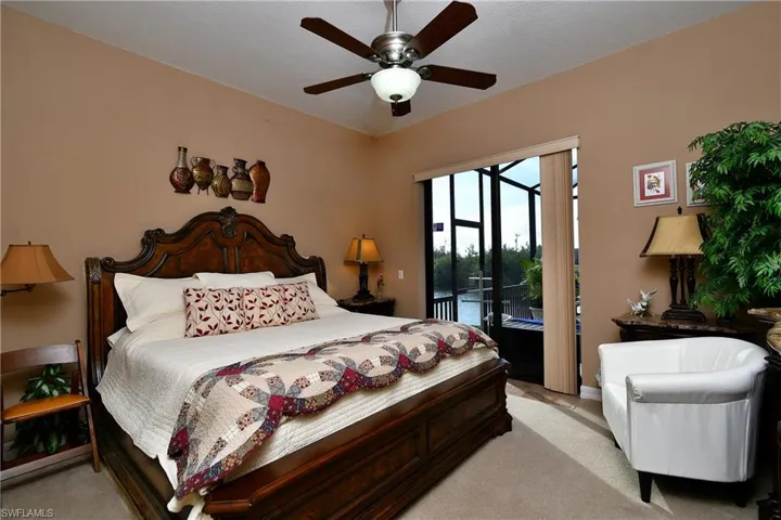 Carpeted bedroom with ceiling fan and access to outside
