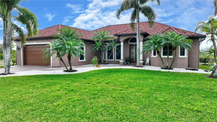 Mediterranean / spanish home with a front lawn and a garage