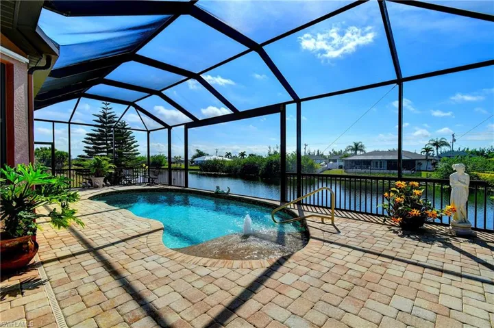 View of swimming pool with a water view, a lanai, and a patio