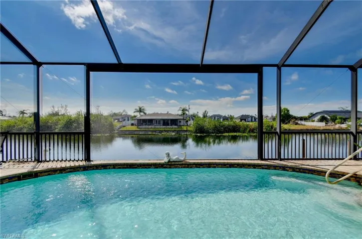 View of pool with glass enclosure and a water view