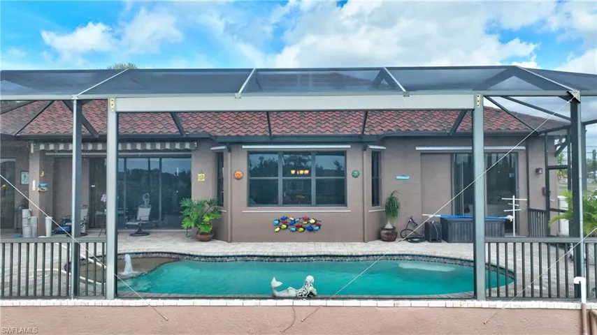 View of pool featuring glass enclosure and a patio area