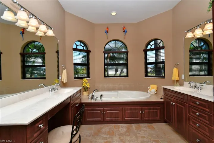 Bathroom with vanity, a tub, and a healthy amount of sunlight