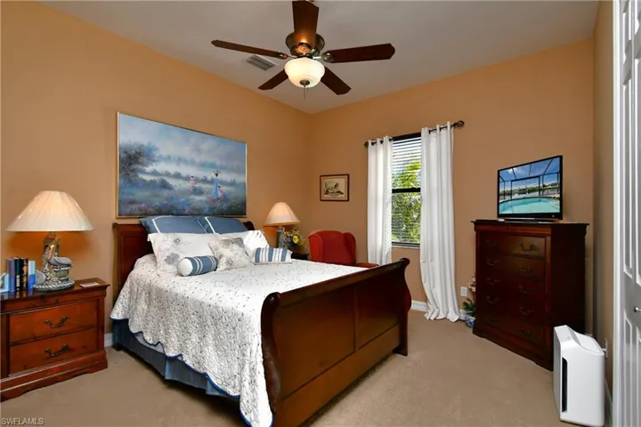 Carpeted bedroom featuring ceiling fan