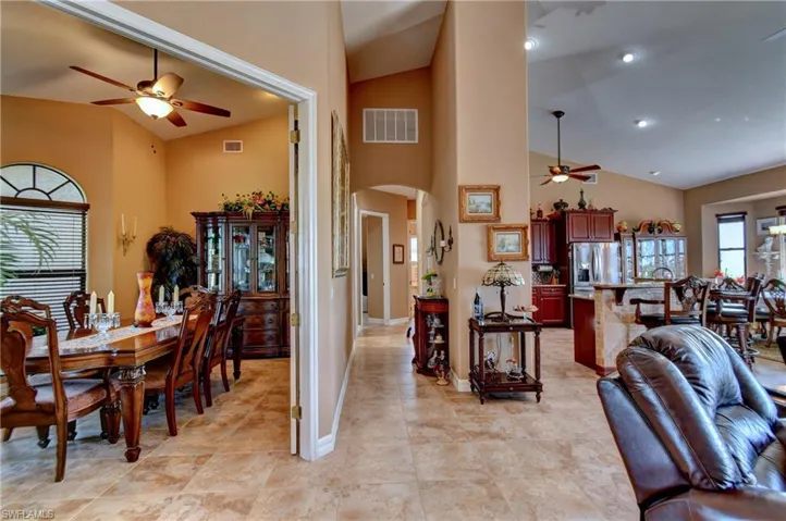 Tiled dining area with high vaulted ceiling and ceiling fan