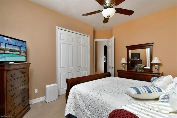 Bedroom featuring light carpet, a closet, and ceiling fan
