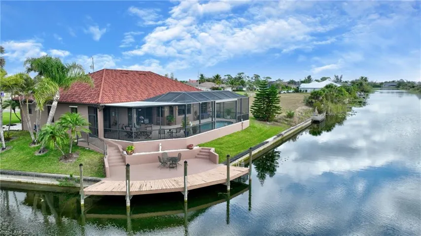 Dock area featuring a patio, a water view, and glass enclosure