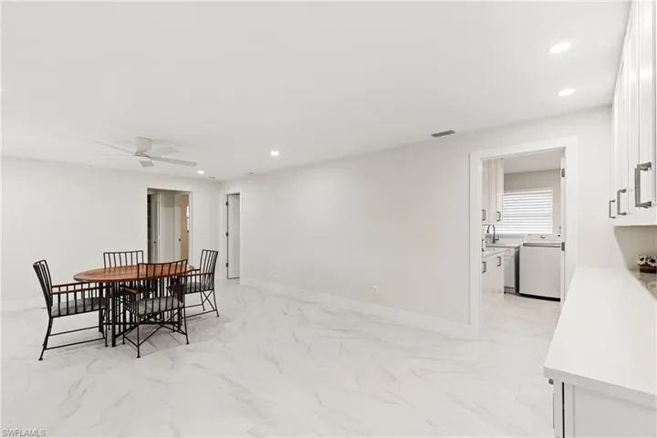 Dining space featuring recessed lighting, light marble finish floors, washer / dryer, and a ceiling fan