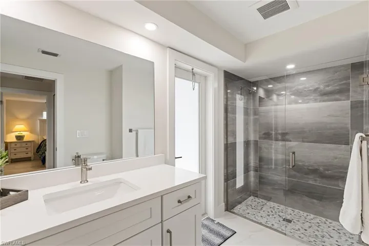 Full bath with a stall shower, vanity, and recessed lighting