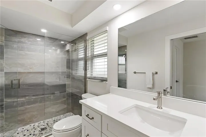 Full bathroom featuring a stall shower, vanity, and recessed lighting