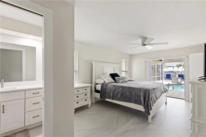 Bedroom with access to exterior, ceiling fan, and light marble finish flooring