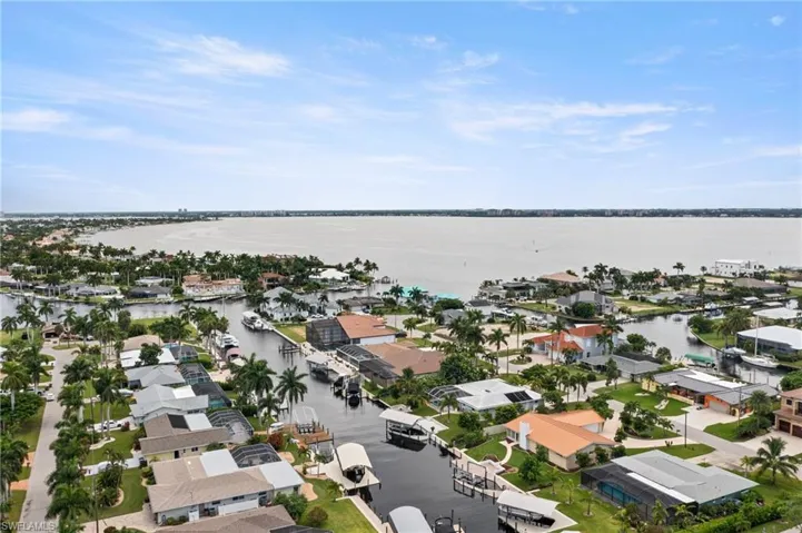 Aerial perspective of suburban area featuring a nearby body of water