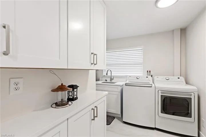Washroom featuring cabinet space and independent washer and dryer