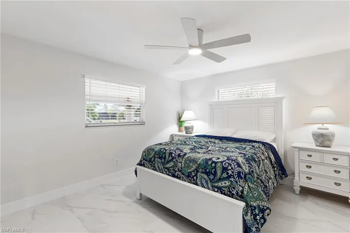 Bedroom featuring light marble finish floors and ceiling fan