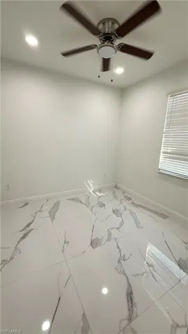 Unfurnished room featuring recessed lighting, ceiling fan, and marble look tile flooring
