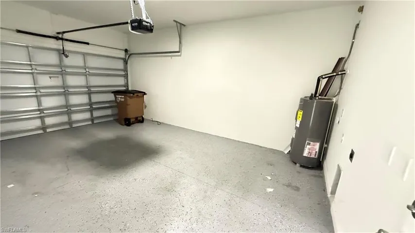 Garage featuring water heater and a garage door opener