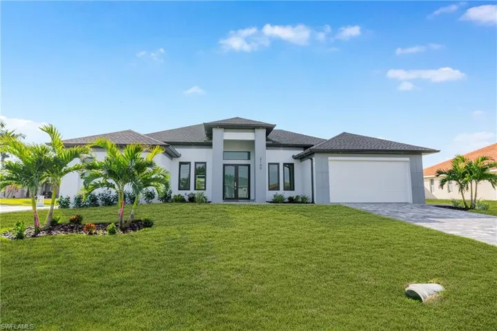 Prairie-style house with a front lawn, decorative driveway, a shingled roof, and french doors