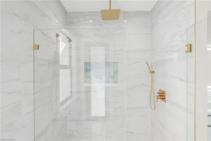 Full bath featuring a marble finish shower