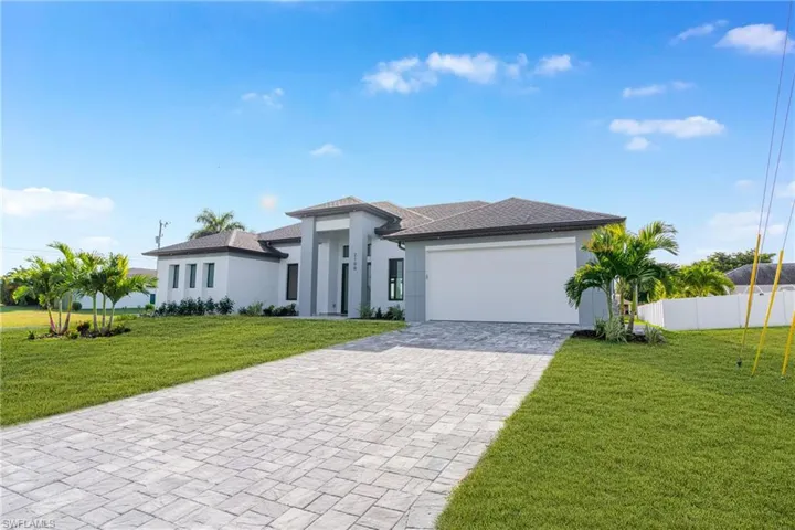 Prairie-style house featuring decorative driveway, stucco siding, and an attached garage
