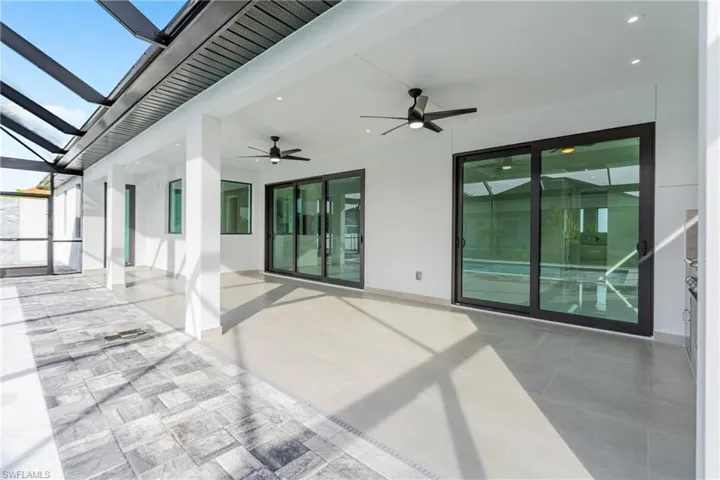 View of patio / terrace with a sunroom, a ceiling fan, and glass enclosure