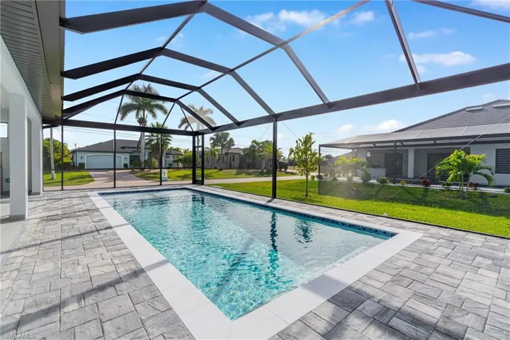 Outdoor pool with a yard, a sunroom, a lanai, and a patio area