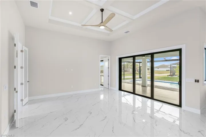 Unfurnished room featuring coffered ceiling, light marble finish floors, a towering ceiling, a ceiling fan, and beam ceiling