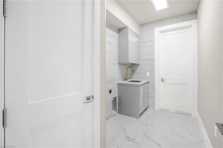 Laundry room featuring light marble finish floors and hookup for an electric dryer