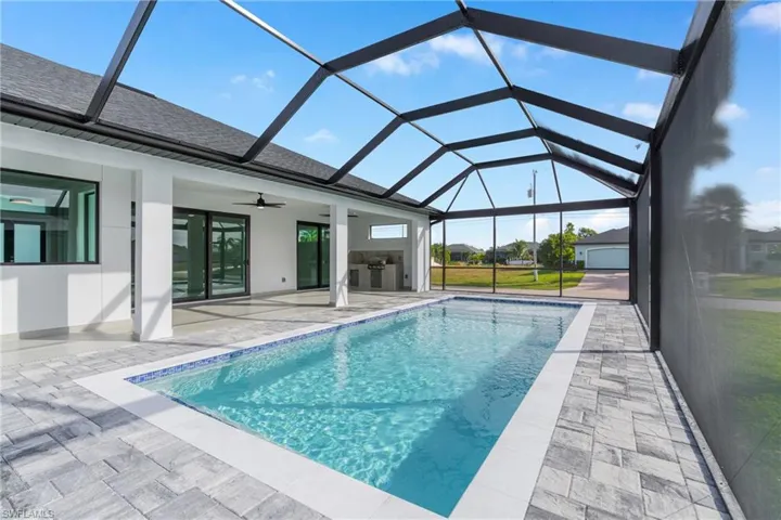 Swimming pool with glass enclosure, a sunroom, and a patio area